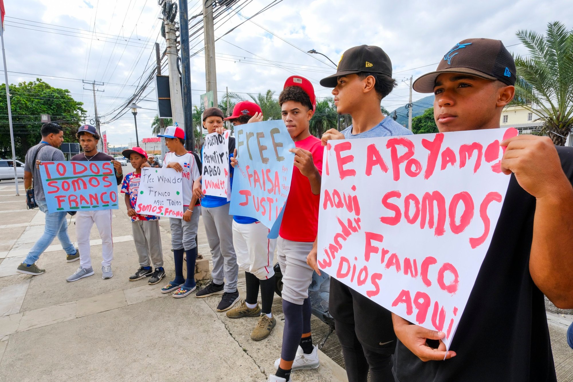 Youth baseball players from the local team "Liga deportiva Antera Mota" show support for Tampa Bay Rays shortstop Wander Franco with posters that read in Spanish: "Free Franco," and "We all are Franco." outside the court where he arrived in Puerto Plata, Dominican Republic, Friday, Jan. 5, 2024. Dominican prosecutors on Wednesday accused Franco of commercial sexual exploitation and money laundering following allegations that he had a relationship with a minor whose mother also faces the same charges. (AP Photo/Ricardo Hernández)
