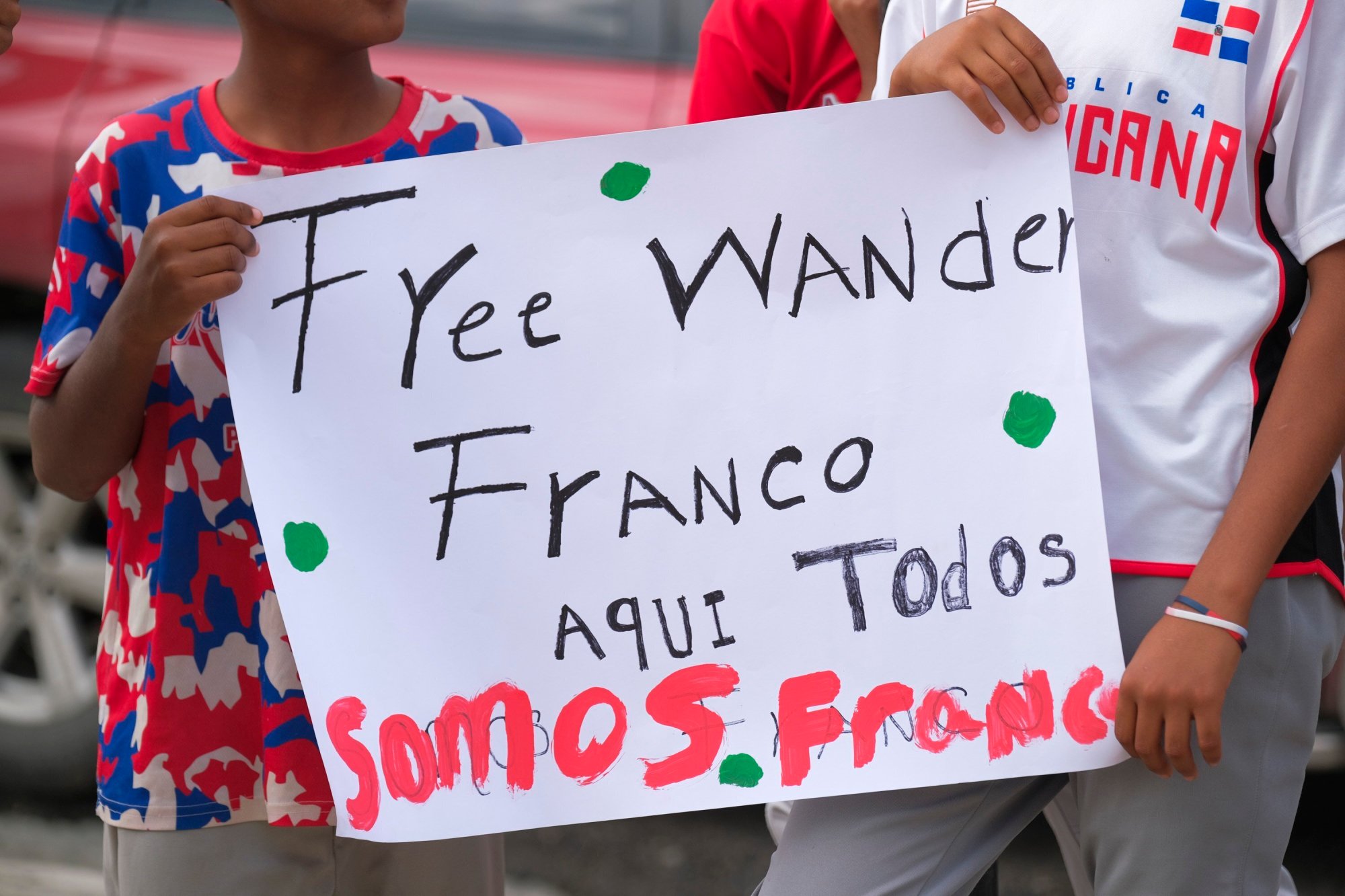 Youth baseball players from the local team "Liga deportiva Antera Mota" show support for Tampa Bay Rays shortstop Wander Franco with posters that read in Spanish: "Free Franco," and "Here we're all Franco." outside the court where he arrived in Puerto Plata, Dominican Republic, Friday, Jan. 5, 2024. Dominican prosecutors on Wednesday accused Franco of commercial sexual exploitation and money laundering following allegations that he had a relationship with a minor whose mother also faces the same charges. (AP Photo/Ricardo Hernández)