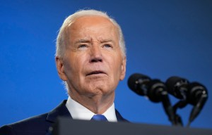 a man in a suit and tie is speaking into a microphone